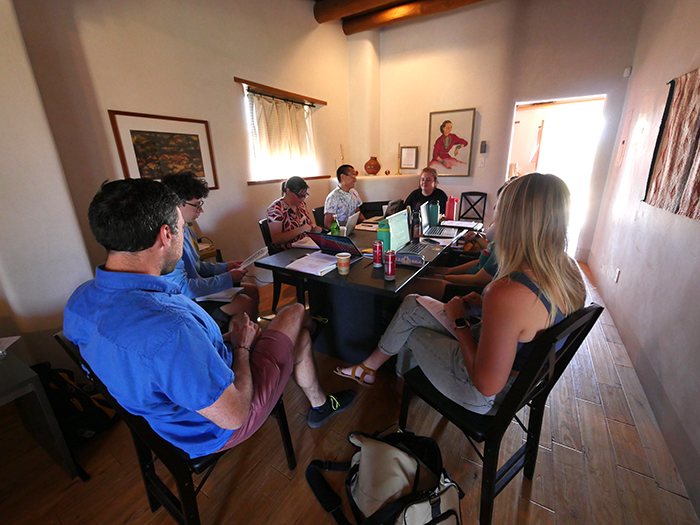 Students sitting at a table with their instructor inside at the Doel Reed Center