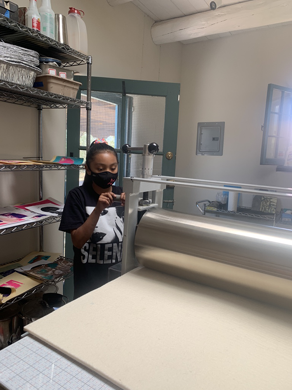 TISA student using print machine at workshop